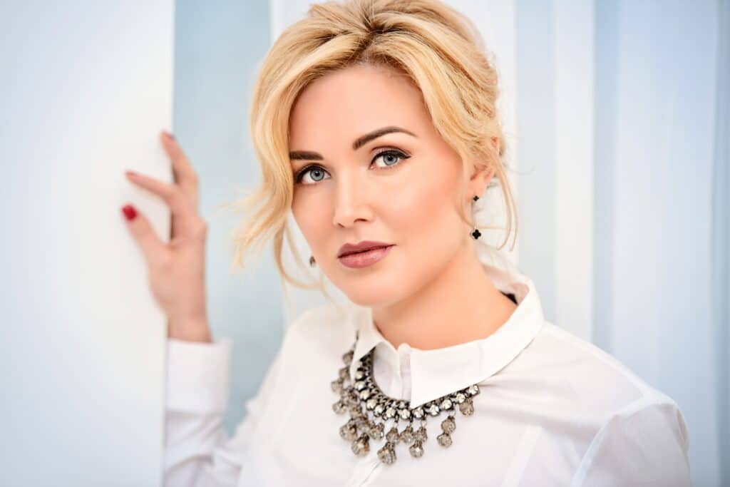 femme en chemisier blanc et collier